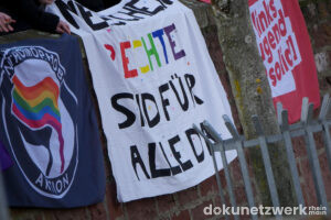 Gegenprotest mit Antifa-Flagge. Transparent mit Beschriftung: »Menschenrechte sind für alle da« . Fahne von linksjugend.