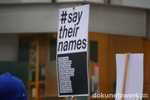 Plakat der Gedenkveranstaltung mit den Gesichtern der Opfer des rassistischen Anschlags in Hanau