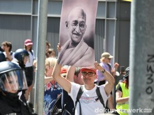 Christoph Barth von der Klartext-Bürgerzeitung mit Plakat von Mahatma Gandhi