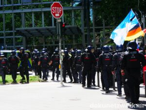 Die Demonstration setzt sich, abgeschirmt durch die Polizei, wieder in Bewegung